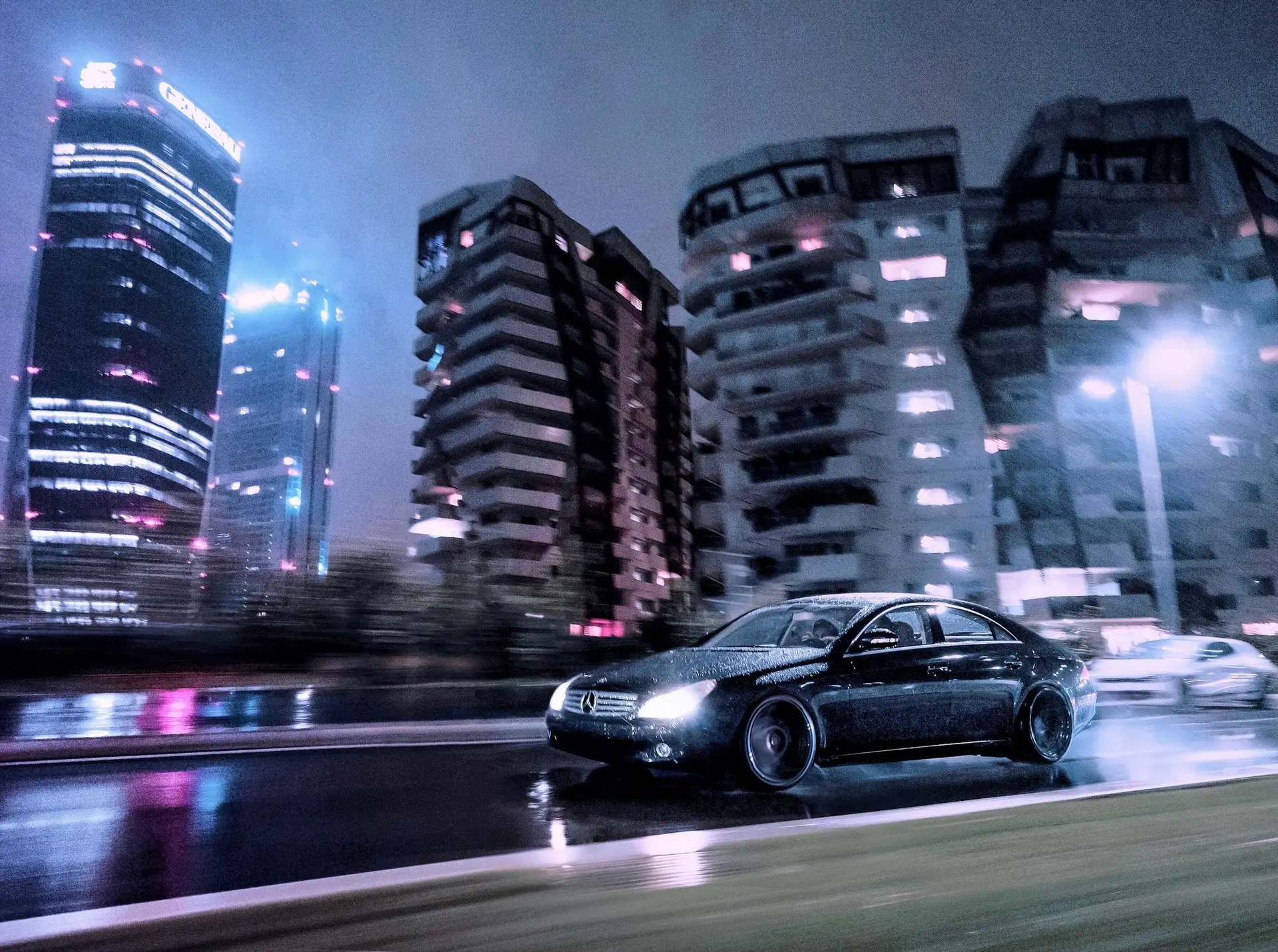 Berline noire de luxe roulant en ville de nuit